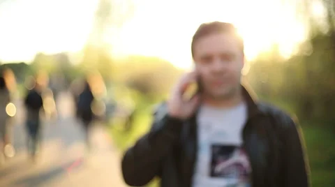 Man talking on Smartphone at Sunset in park. Blur. Out of Focus. HD 1080. Stock-Footage 49751432