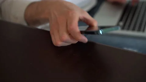 Man talking on smartphone while sitting on couch with laptop, working remotely Stock Footage 154796381