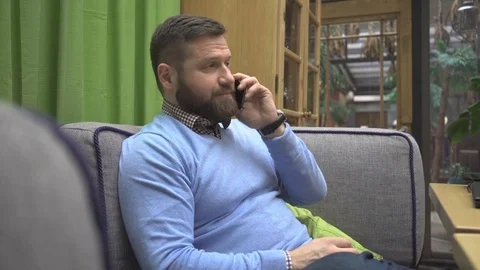 Man talking by smartphonre, in pub, cafe, indoor, steadycam shot 库存影片 73076088