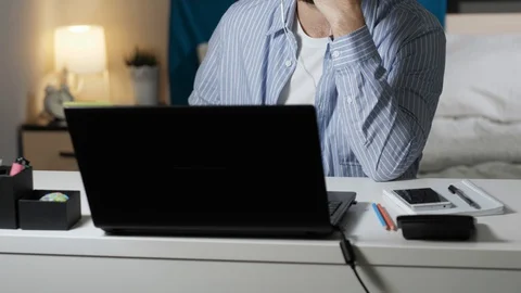 Man is talking on video connection. Bearded guy in headphones sits at table in Stock Footage 129372793
