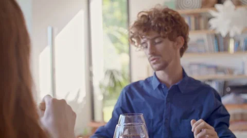 Man talking while eating meal together, drinking wine.Friends enjoy modern home Video stock 128920787