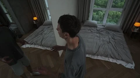 Man talks to mirror reflection in bedroom, mental health crisis concept. 스톡 동영상 312277316