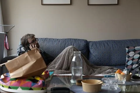 A man talks on the mobile phone while resting on the sofa Foto stock