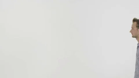 Man talks nervously on a cell phone on white background. 動画素材 80318424