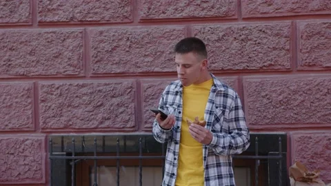 Man talks on the phone and eats. video 4k Vídeo Stock 156550320