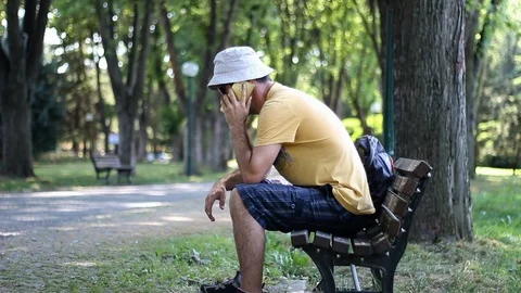 Man talks with phone while relaxing in the park under trees summer day Stock Footage 112359537