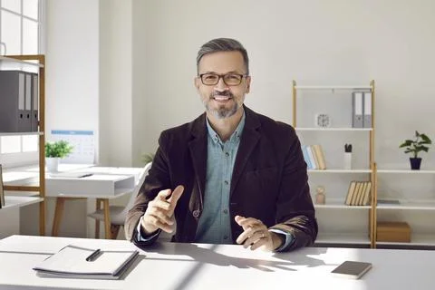 Man talks via web camera with participants of online conference or provides Stock Photos
