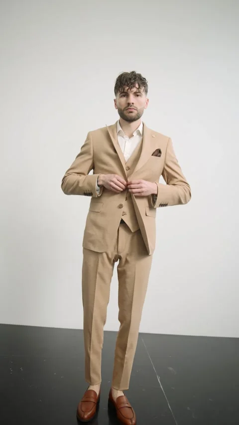 Man in tan suit standing on black surface Video stock 274163472