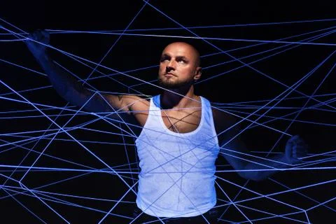 Man tangled in white threads with hands up Stock Photos