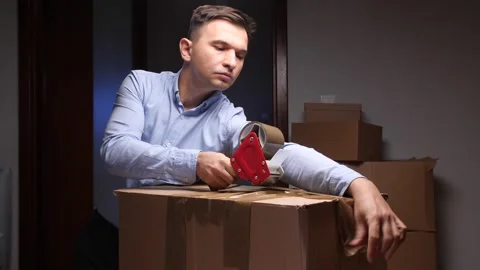 Man taping cardboard box preparing for move Stock Footage 318981647