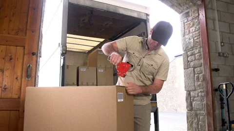 Man taping up a parcel / package before shipping. Logistics in the warehouse. Stock Footage 125133166