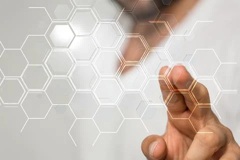 Man tapping on a 3D rendering hologram of a network of hexagons Stock Photos