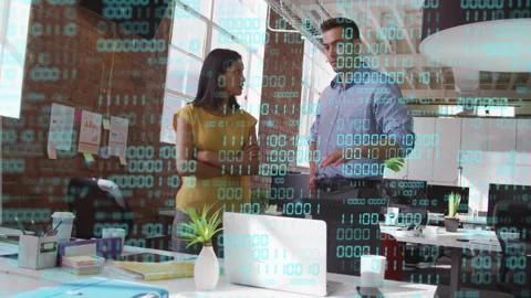 Man tapping laptop and gesturing, woman reviewing tech data while binary digits Stock Footage 333145820