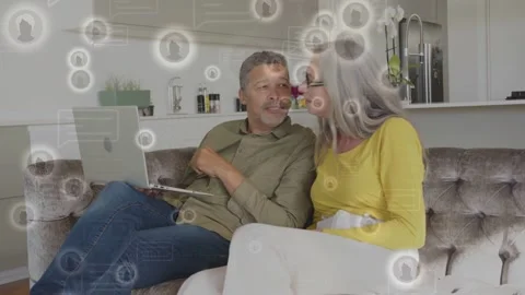 Man tapping laptop screen, causing floating circular UI showing finances, couple Stock Footage 333859483