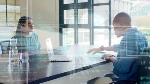 Man tapping pad and adjusting laptop, woman observing code HUD overlaying laptop Stock Footage 330305035