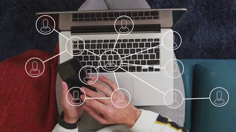 Man tapping phone and typing on laptop, animating network nodes and linking Stock Footage 334351612