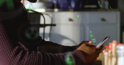 Man tapping phone on table, causing green holograms showing energy data floating Stock Footage 329833351