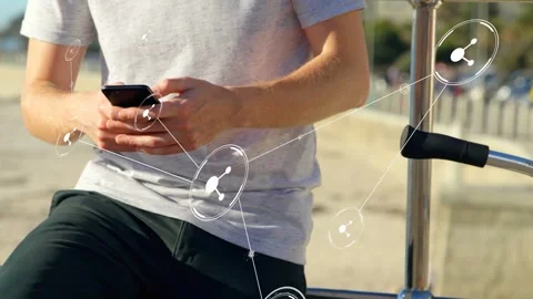 Man tapping smartphone and generating tech network nodes linking across beach Stock Footage 333602291