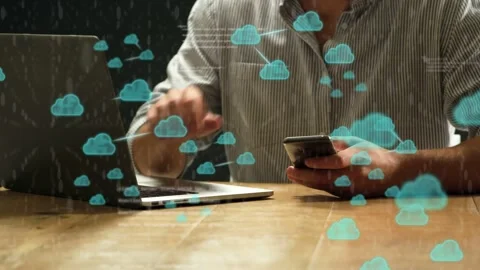 Man tapping smartphone and typing laptop, spawning cloud icons linking to tech Stock Footage 334465965