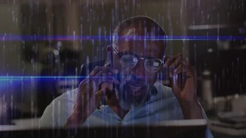 Man tapping smartphone on call, adjusting glasses and resolving tech at desk, Stock Footage 320213270
