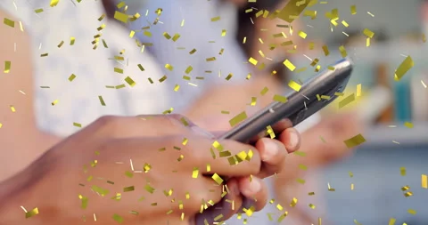 Man tapping smartphone screen in tech initiating gold confetti burst celebrating Stock Footage 312693654