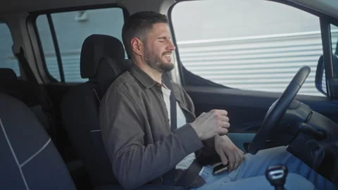 Man tapping smartphone, smiling and occasionally fist pumping with seatbelt.. Stock Footage 337363353
