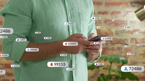 Man tapping smartphone in studio checking tech app while notification badges and Stock Footage 335283015