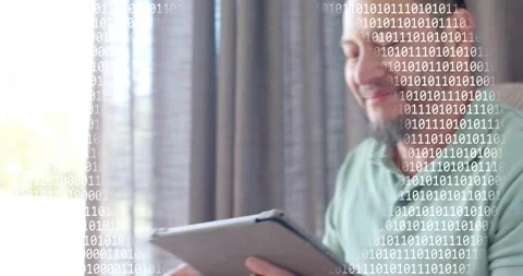 Man tapping tablet and causing binary code overlay while viewing technology Stock Footage 318307403