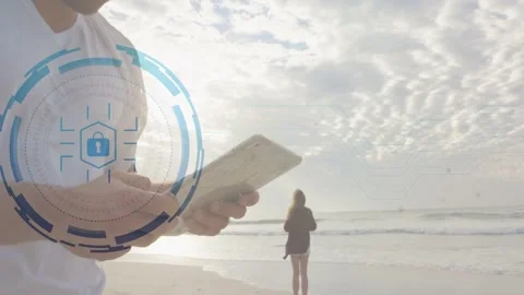 Man tapping tablet on beach causing animated tech HUD and revealing locked data Stock Footage 335317720