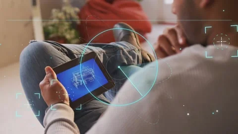 Man tapping tablet on couch, swiping to rotate 3D schematic, HUD scan Stock Footage 333632032