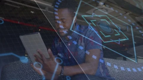 Man tapping tablet, leaning in tech lounge, blue AR overlays moving around him Stock Footage 333719845