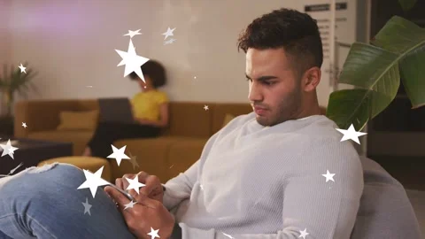 Man tapping tablet in lounge and testing tech interface, animated stars drifting Stock Footage 333657249