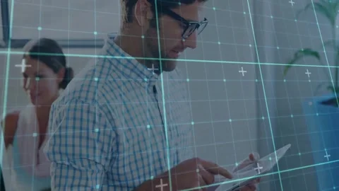 Man tapping tablet in office while woman typing on computer, showing technology Stock Footage 328005607