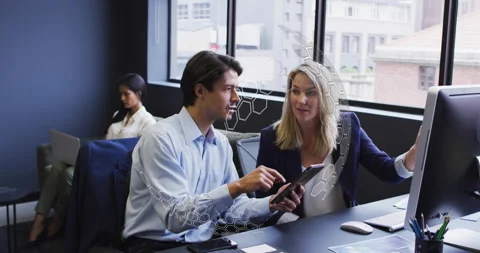 Man tapping tablet screen and pointing at monitor while collaborating on Stock-Footage 314349338