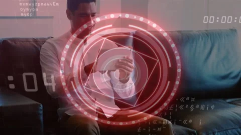 Man tapping tablet on sofa, activating tech HUD with morphing rings, countdown Stock Footage 333964877