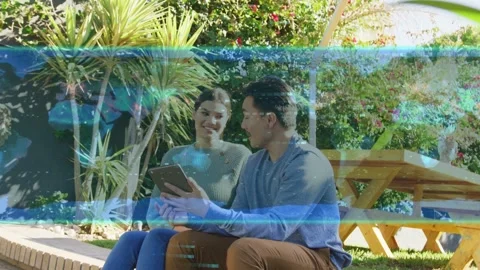 Man tapping tablet, tilting, sharing; woman leaning, laughing; tech overlay Stock Footage 333300691
