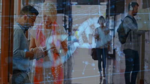 Man tapping tablet while woman pointing in hall, causing faint DNA helix overlay Stock Footage 333902405