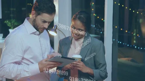 Man tapping tablet while woman pointing, reviewing business data with floating Stock Footage 335739313
