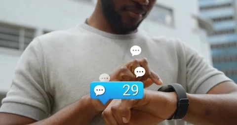 Man tapping watch screen, causing chat bubble and tech icons rising around Stock Footage 321377879