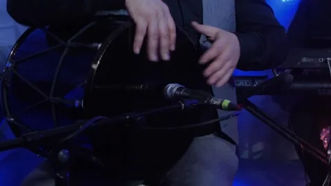 Man taps hands on black drum near microphone in restaurant Stock-Footage 247761563