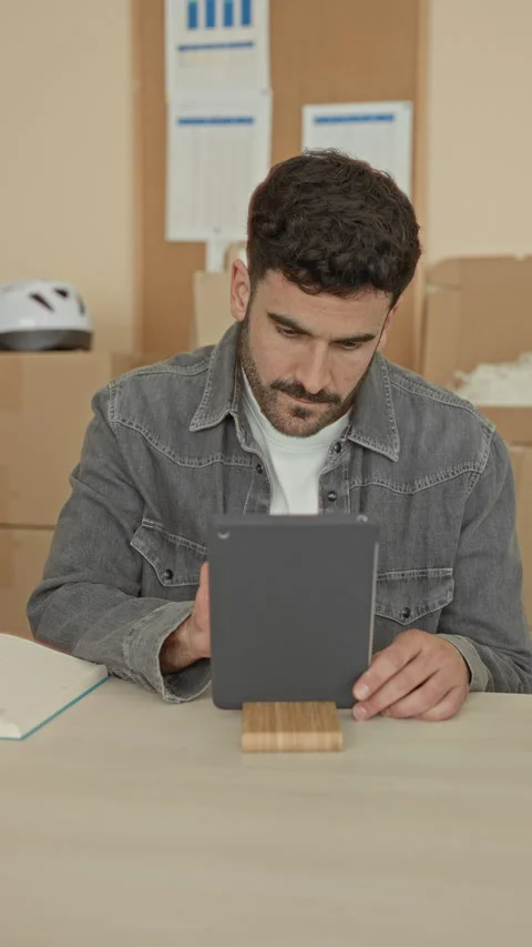 Man taps tablet with stylus, hands visible, checking parcels on table with .. Stock Footage 337373339