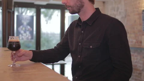 Man Tasting Dark Beer from Glass at Bar Counter Close Up Stock Footage 346028023