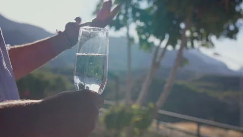 Man tasting white wine and talking gesturing, reflection of sun rays in glass Stock Footage 314520694