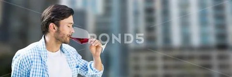 Man tasting wine against blurry buildings Stock Photos