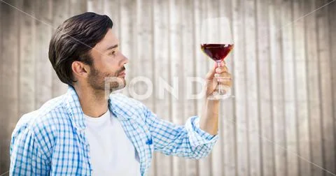 Man tasting wine against blurry wood panel Stock Photos
