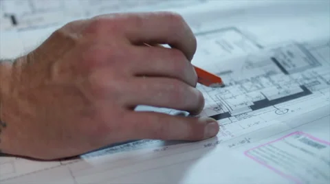 Man with tatoos Pensively Looking over Blueprints Stock Footage 40646376