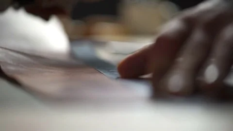 A man with tattoos cutting leather with a sharp knife in the workshop closeup Stock Footage 71486699