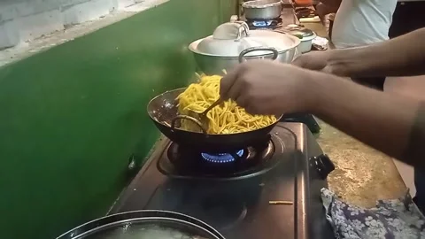 A man with tattoos on his hands is cooking instant noodles in the kitchen. Stock Footage 304337570