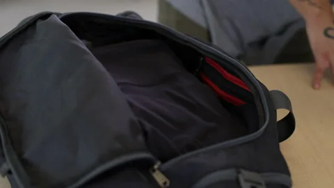 Man with tattoos packing a duffel bag Stock Footage 218633475