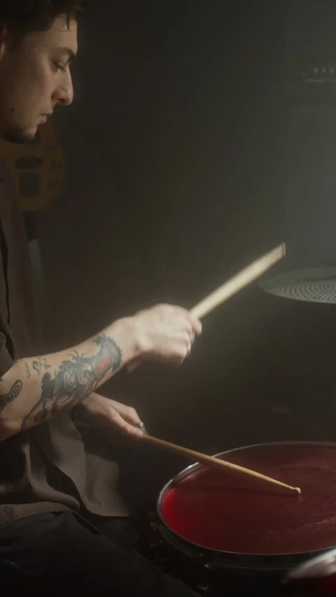Man with Tattoos Playing Snare Drum in Dark Music Studio Stock Footage 338406631